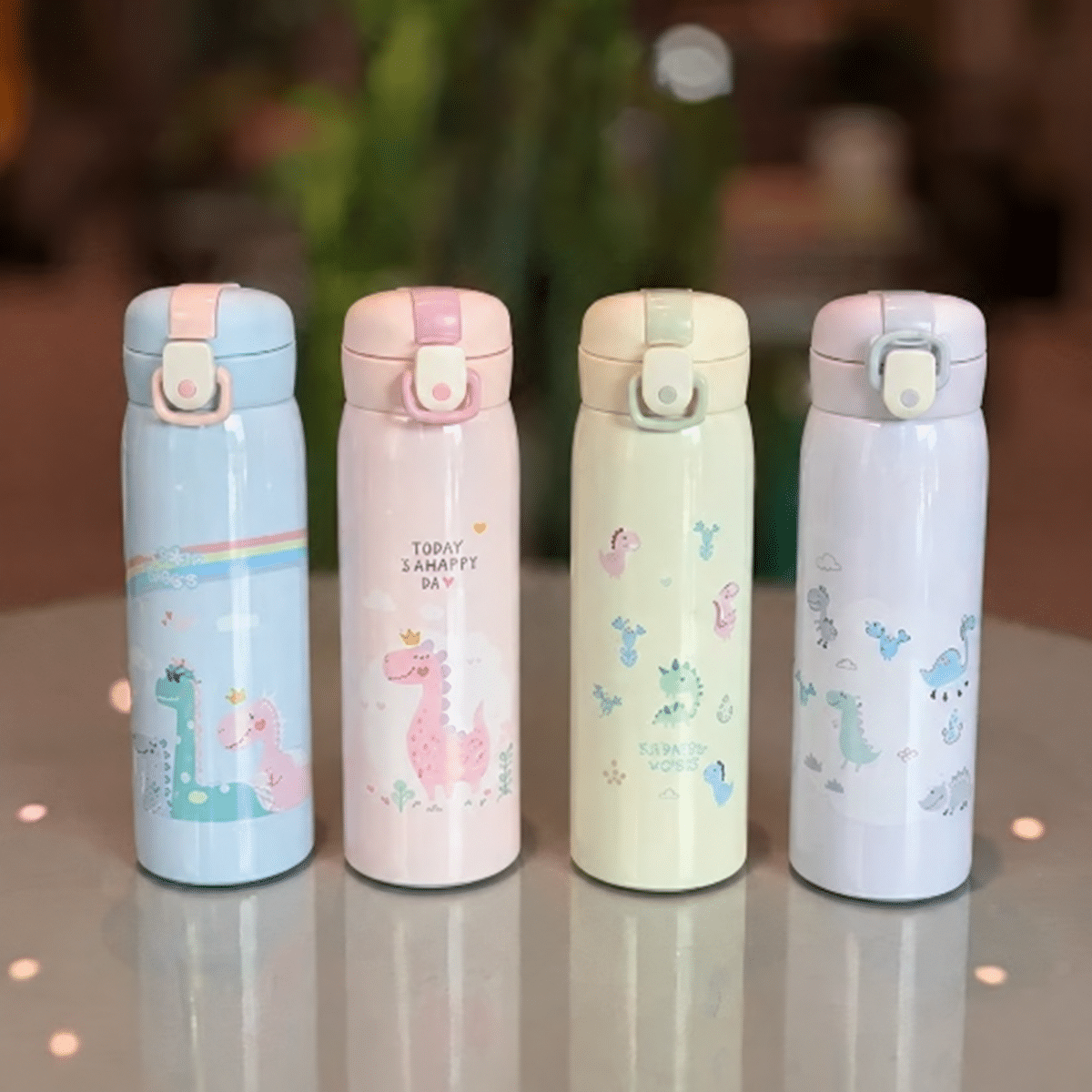 Four pastel dinosaur bottles on tabletop تراول طرح دایناسور 500 میل - تصویر 1