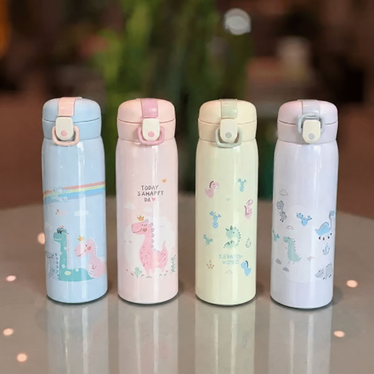 Four pastel dinosaur bottles on tabletop تراول طرح دایناسور 500 میل - تصویر 1